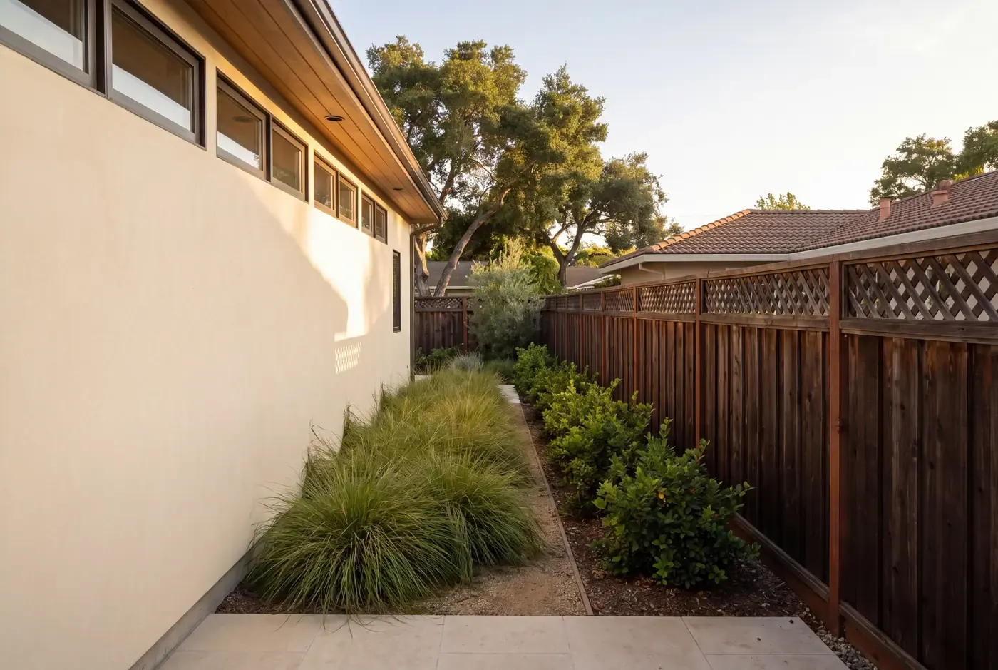 A detached ADU side wall with clerestory windows placed high to bring in light while maintaining privacy from the neighboring yard