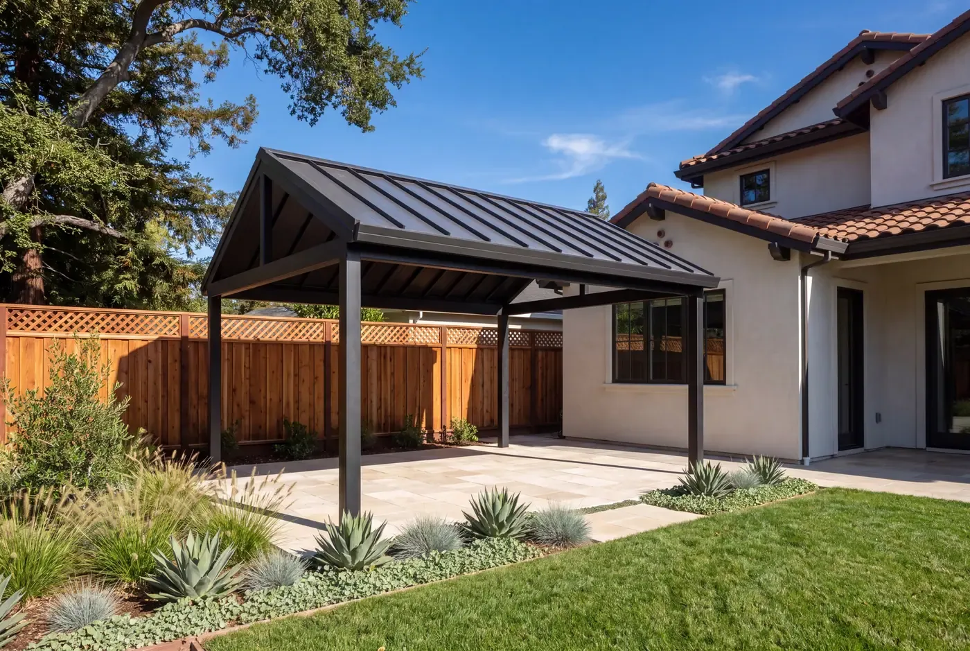 Completed detached patio cover with structural columns and poured concrete footing exposed near grade