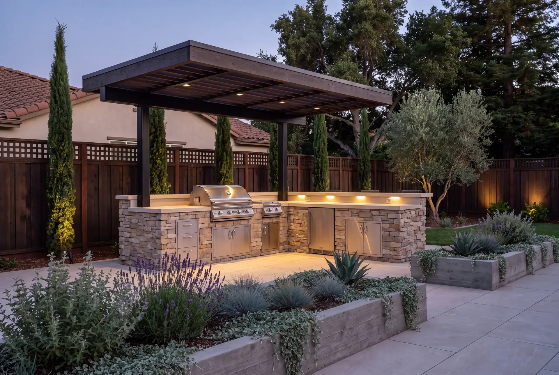 Outdoor kitchen with stainless steel appliances, porcelain countertops, and stone veneer cladding in a South Bay backyard